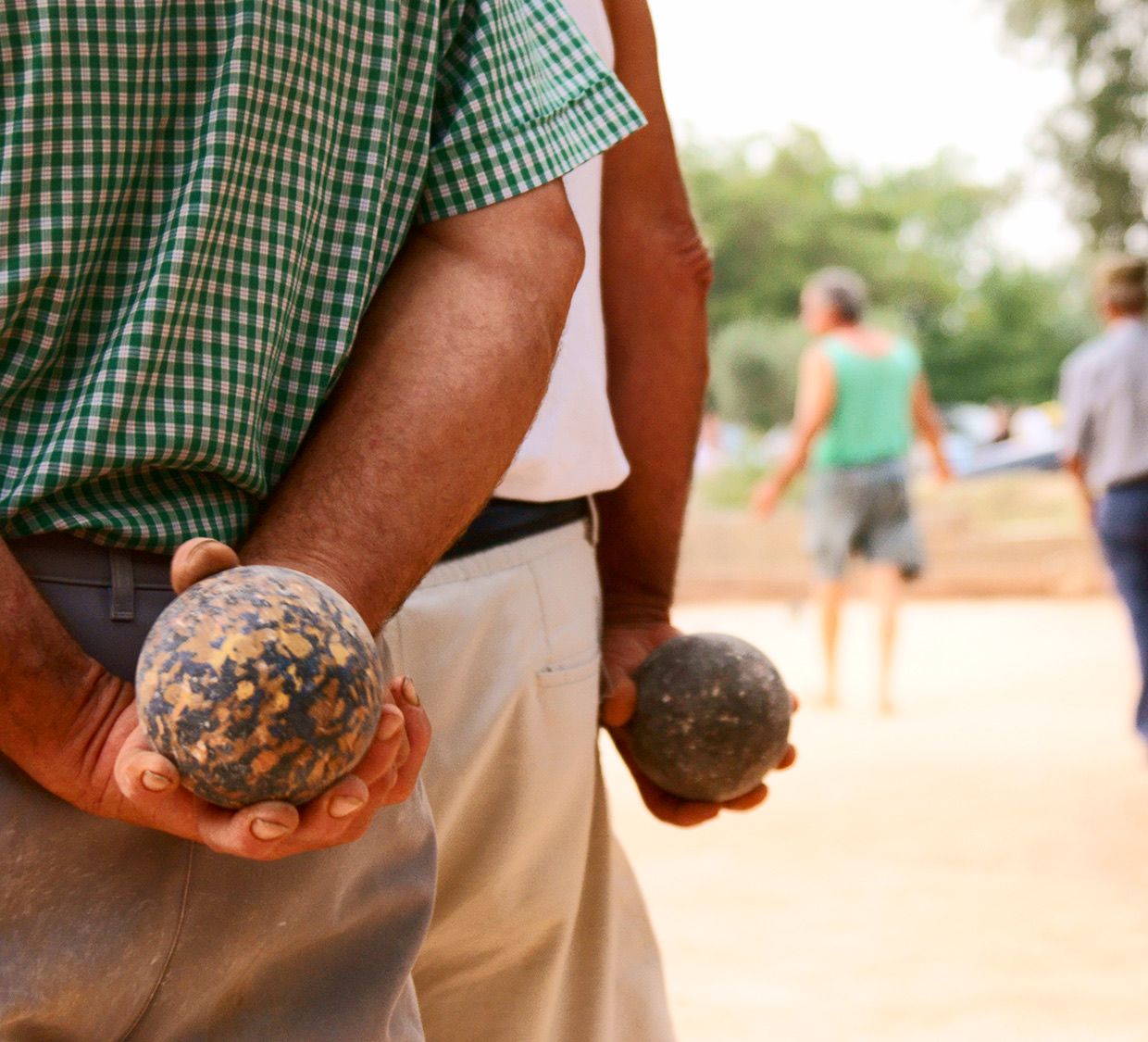 Due giocatori con le bocce in mano, dietro la schiena